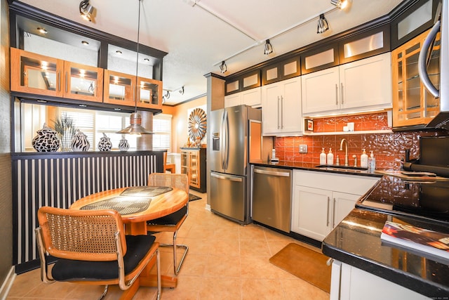 85 Viscount Dr Unit 10A, Milford, CT 06460 - kitchen featuring appliances with stainless steel finishes, a sink, rail lighting, dark countertops, and light tile patterned flooring