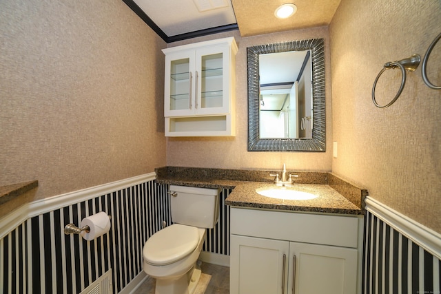 85 Viscount Dr Unit 10A, Milford, CT 06460 - bathroom with toilet, vanity, wainscoting, ornamental molding, and a decorative wall