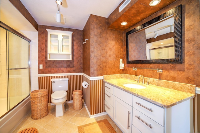 85 Viscount Dr Unit 10A, Milford, CT 06460 - full bathroom with toilet, tile patterned floors, vanity, shower / bath combination with glass door, and wainscoting