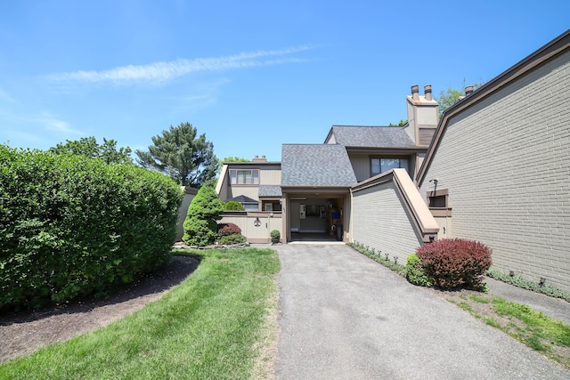 85 Viscount Dr Unit 10A, Milford, CT 06460 - view of front of house with a chimney, roof with shingles, and driveway