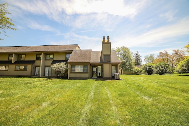 85 Viscount Dr Unit 10A, Milford, CT 06460 - back of house with a chimney, central air condition unit, and a lawn