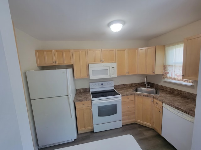kitchen featuring white appliances, light brown cabinetry, a sink, dark wood-type flooring, and dark countertops