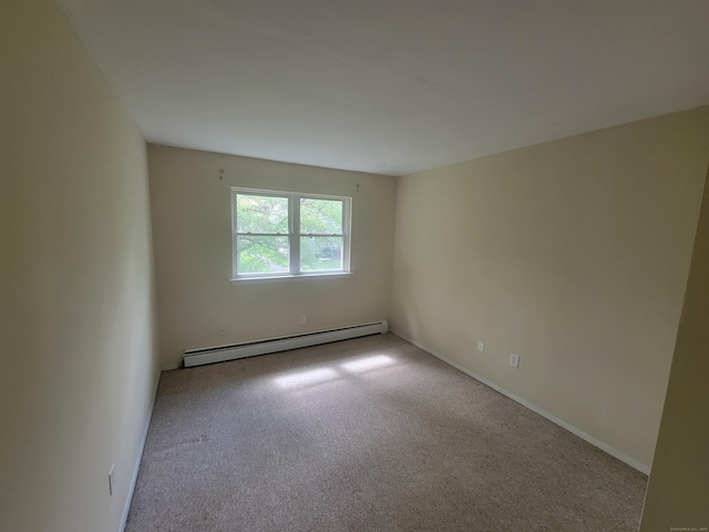empty room with a baseboard heating unit and carpet flooring