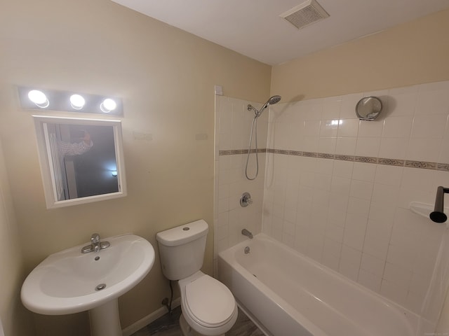 bathroom with toilet, shower / bathtub combination, and a sink