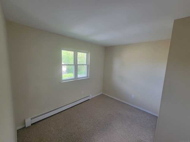 carpeted spare room featuring baseboard heating and baseboards