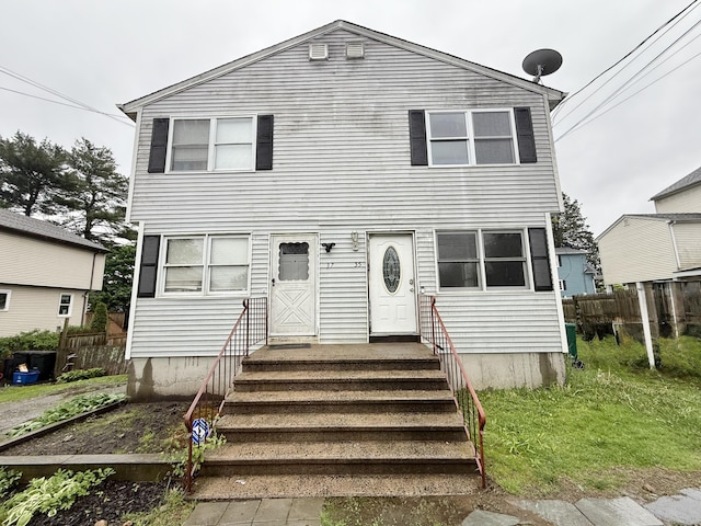 traditional-style house featuring fence and entry steps