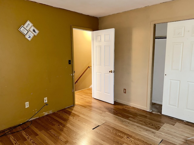 unfurnished bedroom with wood finished floors and baseboards