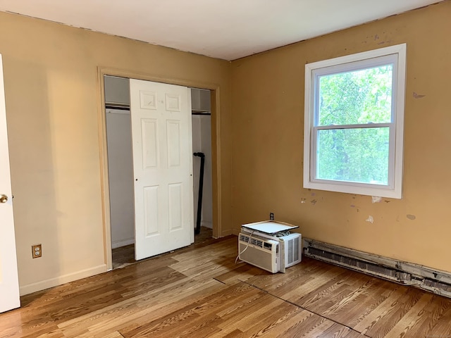 unfurnished bedroom with light wood finished floors, multiple windows, and a closet
