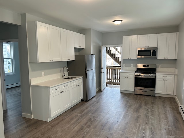 kitchen featuring stainless steel appliances, a baseboard radiator, light countertops, dark wood-style flooring, and white cabinets