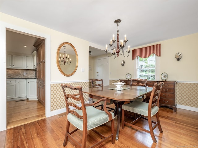 61 Nod Hill Rd, Wilton, CT 06897 - dining space with a chandelier, a wainscoted wall, light wood-style flooring, and baseboards