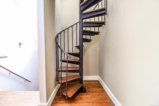 stairs with wood finished floors and baseboards