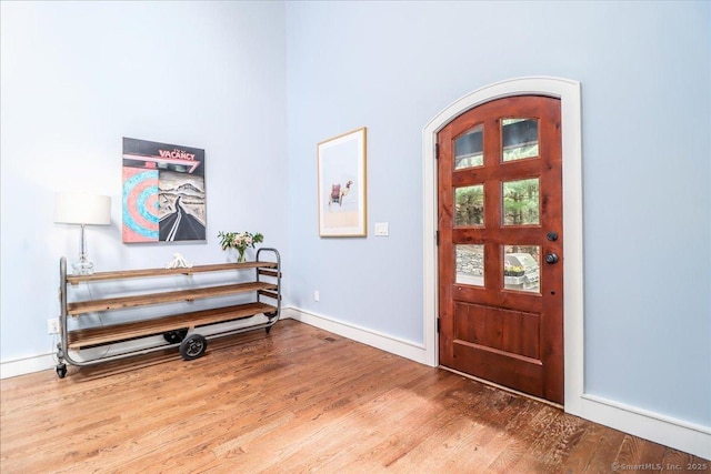 foyer entrance with wood finished floors and baseboards