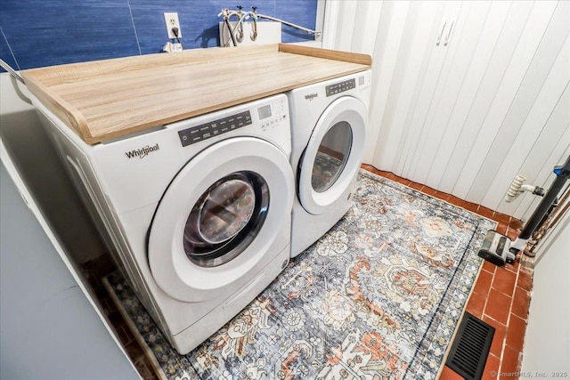 clothes washing area with washing machine and dryer and tile patterned flooring
