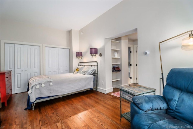 bedroom with two closets and wood finished floors