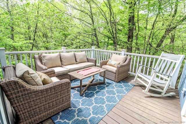 deck featuring an outdoor living space and a view of trees