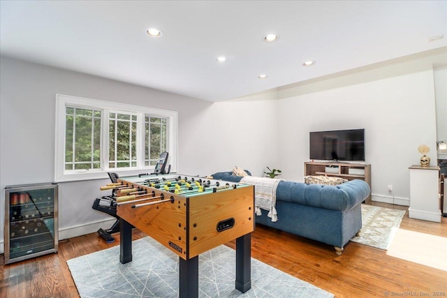 recreation room with wine cooler, recessed lighting, wood finished floors, and baseboards