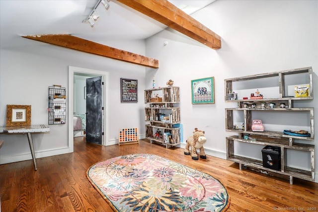 sitting room with lofted ceiling, wood finished floors, rail lighting, and baseboards