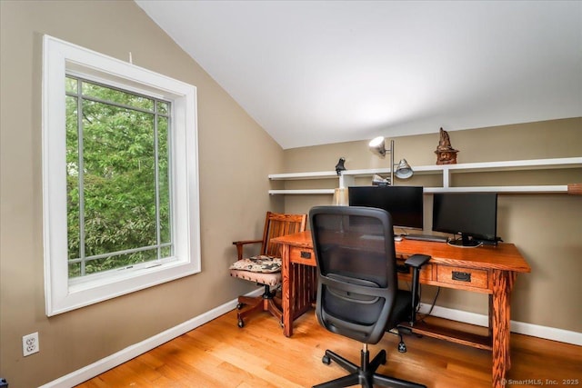 office space with wood finished floors, vaulted ceiling, and baseboards