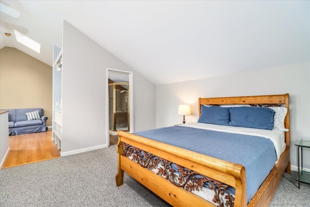 bedroom featuring carpet, lofted ceiling, a skylight, and baseboards