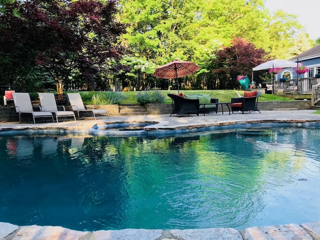 view of swimming pool featuring a patio area, a deck, a pool with connected hot tub, and outdoor lounge area