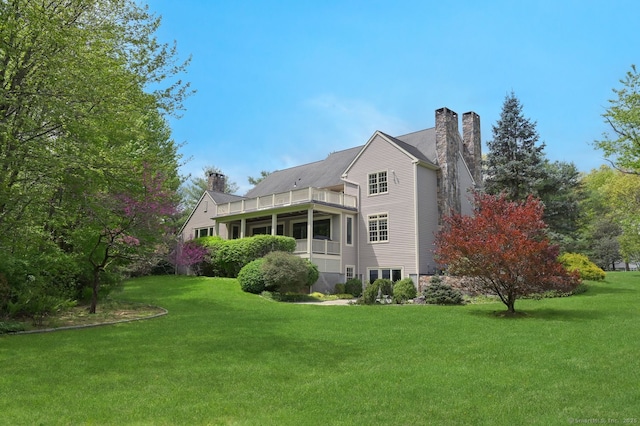 6 Spectacle Ln, Ridgefield, CT 06877 - rear view of house with a chimney, a balcony, and a lawn