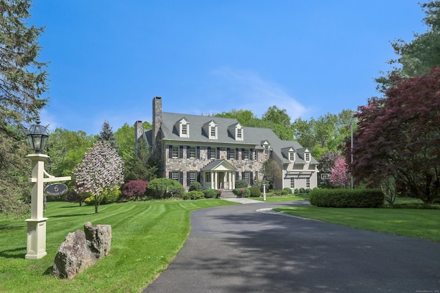6 Spectacle Ln, Ridgefield, CT 06877 - view of front of home with stone siding, a chimney, and a front lawn