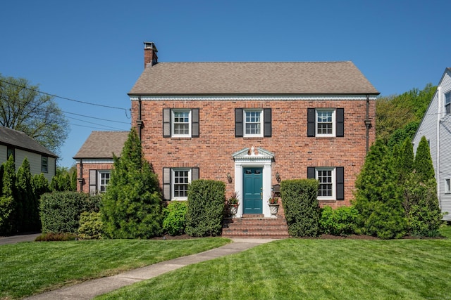 341 Quaker Ln N, West Hartford, CT 06119 - colonial inspired home with a chimney, brick siding, a front lawn, and a shingled roof