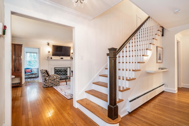 341 Quaker Ln N, West Hartford, CT 06119 - stairway featuring baseboard heating, hardwood / wood-style flooring, ornamental molding, a fireplace, and baseboards
