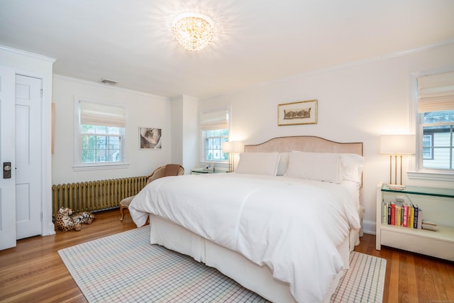 341 Quaker Ln N, West Hartford, CT 06119 - bedroom with radiator heating unit, multiple windows, wood finished floors, and crown molding