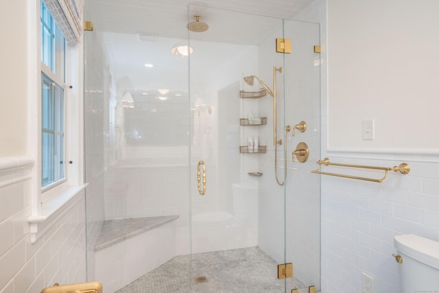 341 Quaker Ln N, West Hartford, CT 06119 - full bathroom with tile walls, toilet, a stall shower, and wainscoting