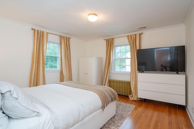 341 Quaker Ln N, West Hartford, CT 06119 - bedroom featuring radiator, multiple windows, wood-type flooring, and crown molding
