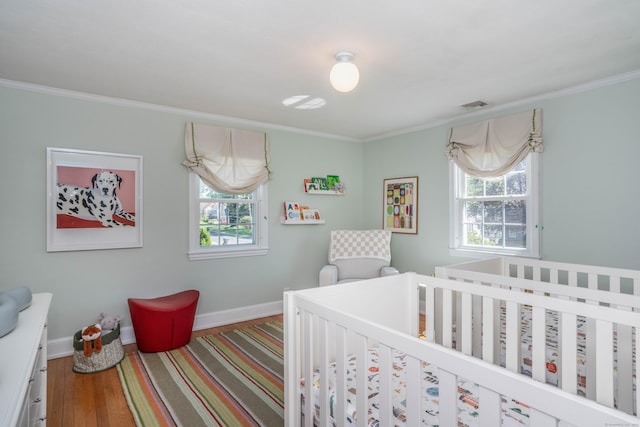 341 Quaker Ln N, West Hartford, CT 06119 - bedroom featuring wood finished floors, crown molding, a nursery area, and baseboards