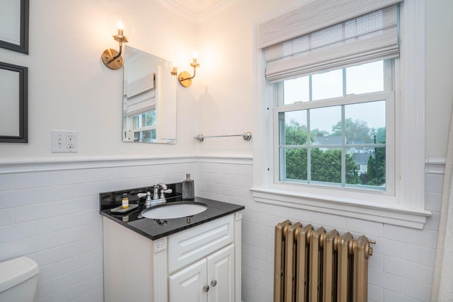 341 Quaker Ln N, West Hartford, CT 06119 - bathroom featuring radiator heating unit, tile walls, toilet, vanity, and wainscoting