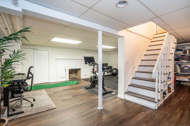341 Quaker Ln N, West Hartford, CT 06119 - workout area with a drop ceiling, wood finished floors, baseboards, and a brick fireplace