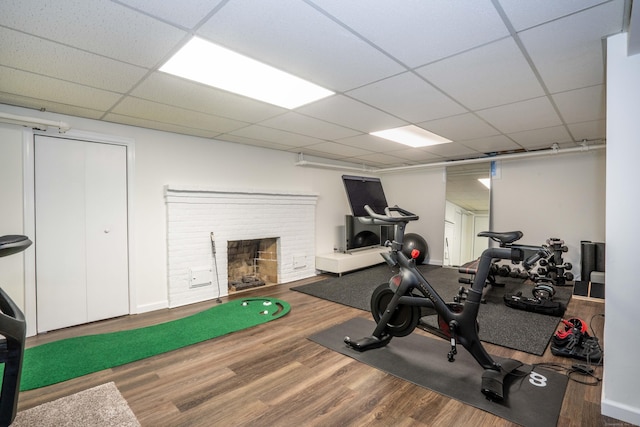 341 Quaker Ln N, West Hartford, CT 06119 - exercise area with wood finished floors, a drop ceiling, and a brick fireplace