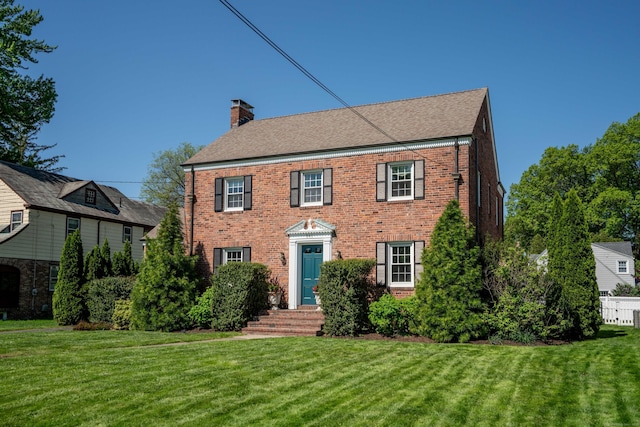 341 Quaker Ln N, West Hartford, CT 06119 - colonial-style house featuring brick siding, a chimney, and a front lawn