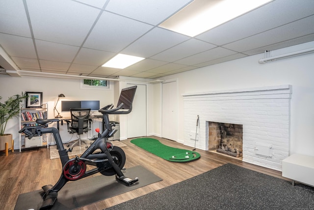 341 Quaker Ln N, West Hartford, CT 06119 - workout room with wood finished floors, a brick fireplace, and a paneled ceiling