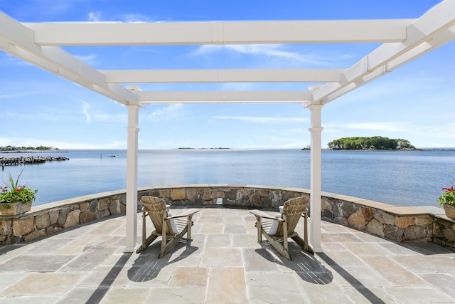view of patio with a pergola and a water view