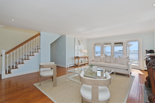 living room featuring stairs, wood finished floors, and a water view