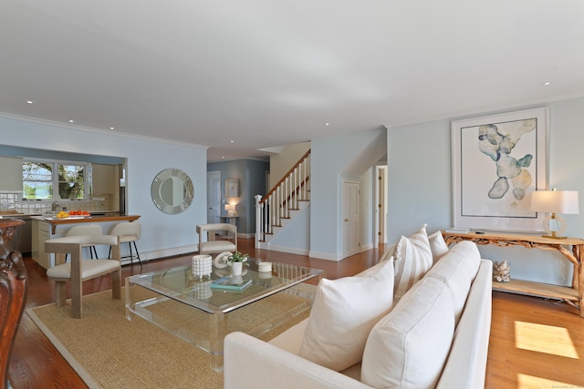 living room with stairway, wood finished floors, a baseboard heating unit, crown molding, and recessed lighting
