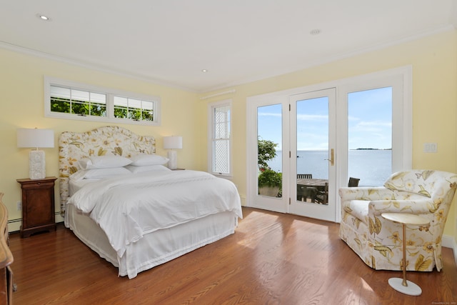 bedroom featuring access to outside, wood finished floors, ornamental molding, a water view, and a baseboard heating unit