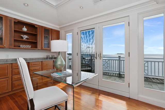 dining space with light wood-style floors, a water view, and recessed lighting
