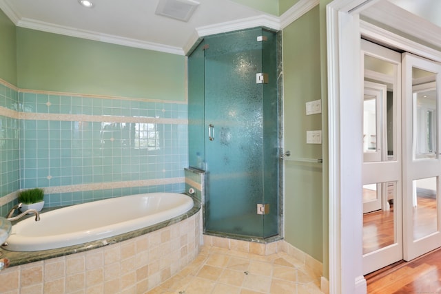 bathroom featuring tile patterned floors, crown molding, a shower stall, and a bath