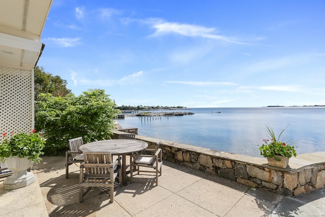 view of patio with a water view and outdoor dining space