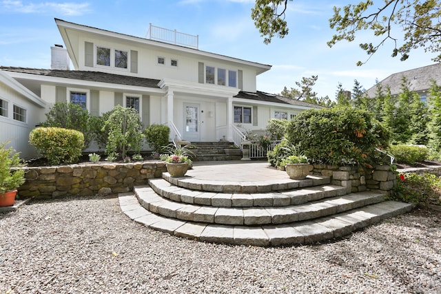 back of property with a chimney and a patio area