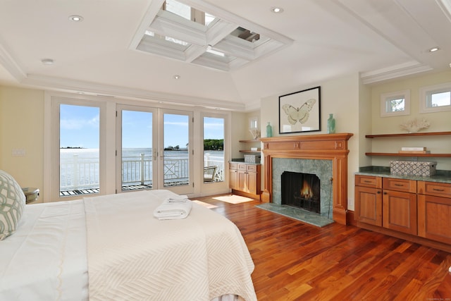 bedroom with wood finished floors, coffered ceiling, access to outside, a fireplace, and a skylight