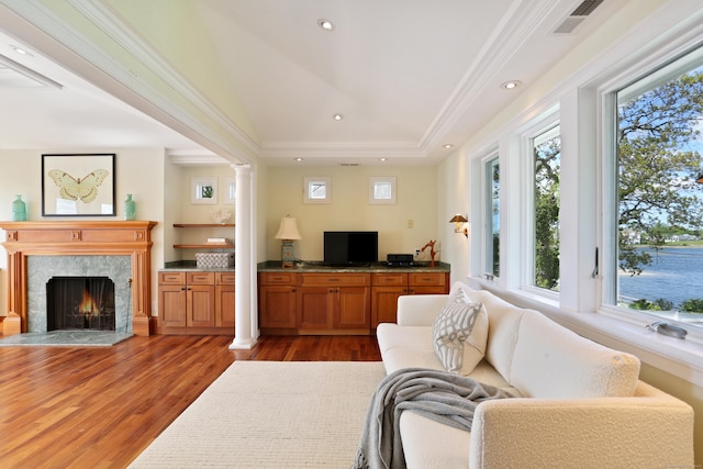 living area featuring wood finished floors, a high end fireplace, ornate columns, recessed lighting, and vaulted ceiling