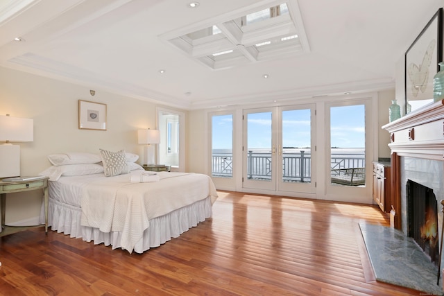 bedroom with a high end fireplace, access to outside, coffered ceiling, light wood-type flooring, and ornamental molding