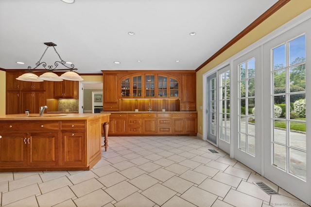 24 Lawrence Hill Rd, Stamford, CT 06903 - kitchen featuring a sink, ornamental molding, light countertops, brown cabinetry, and backsplash