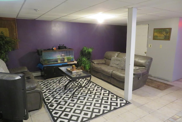 living room with a baseboard heating unit, a paneled ceiling, and tile patterned floors